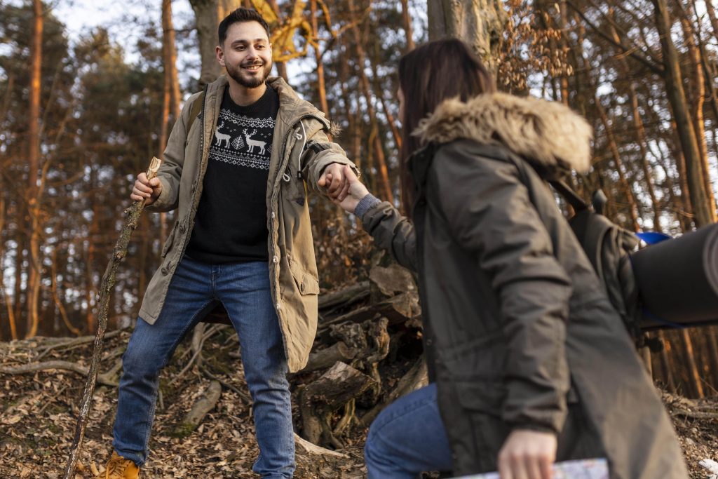 dvoj ekolega pomažu jedno drugom u toku team buildinga na otvorenom , motivacija nakon team buildinga
