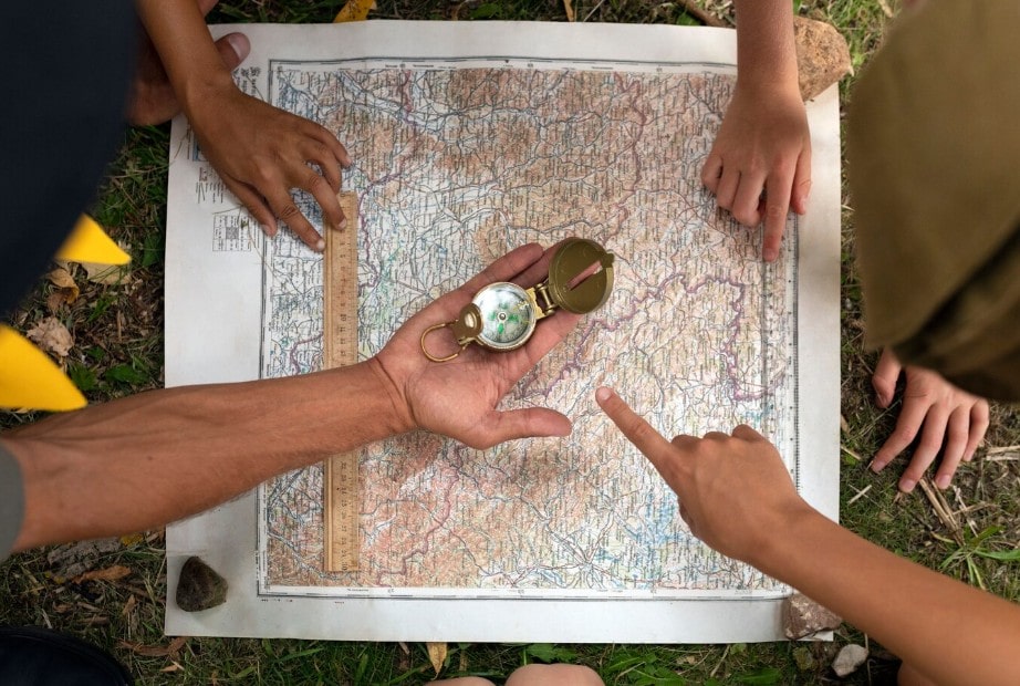 Survival scenariji za timove: Šta kada izgubite vođu? 2 nekoliko kolega gleda u mapu i kompas pokušavajući da se orijentiše