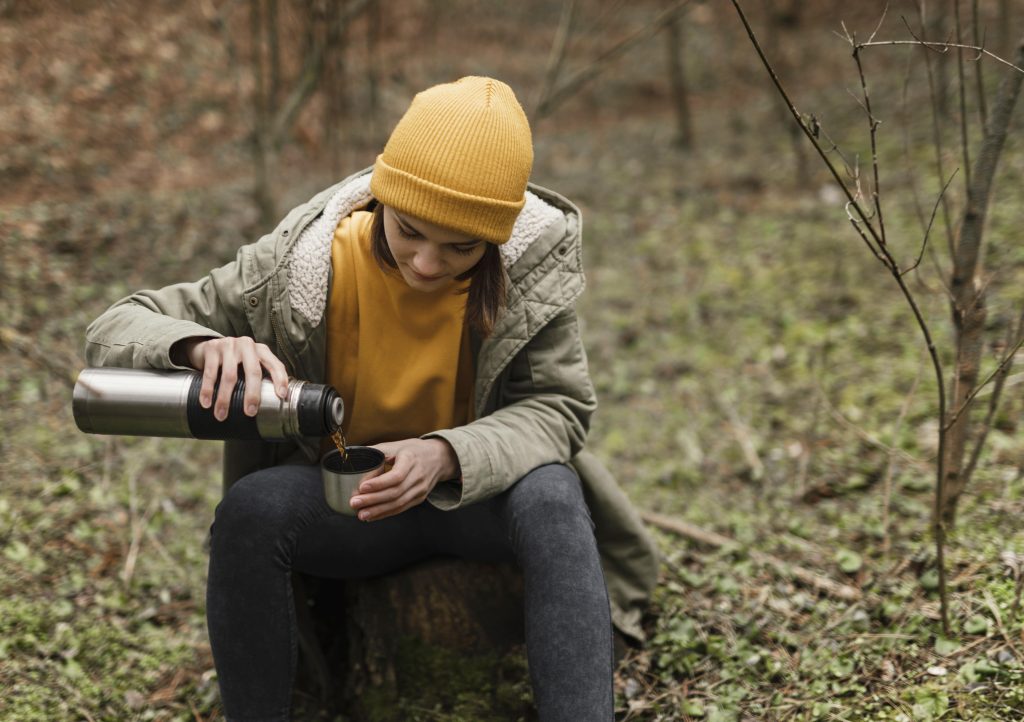 žena koristi filter za vodu u prirodi, tehnologija u survivalu
